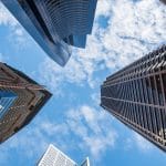 looking-up-through-skyscrapers-under-construction-with-blue-sky-rltheis_t20_rOrVoX